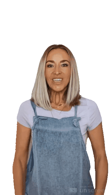 Animated gif of a blond woman with a pale purple shirt and denim overalls clapping joyfully